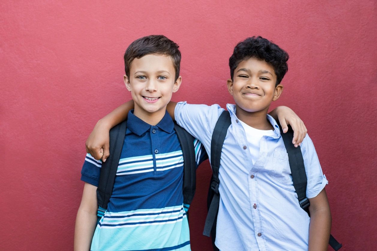 Two boys are posing for a picture together.