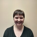 A woman with short hair smiles for the camera.